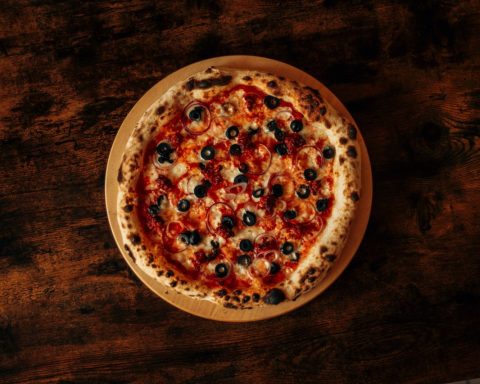 Versgebakken pizza op een houten tafel