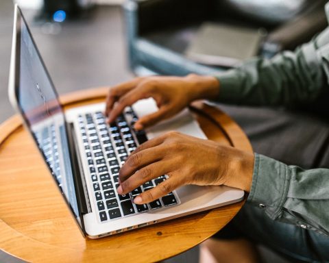 Handen typen op een kleine laptop